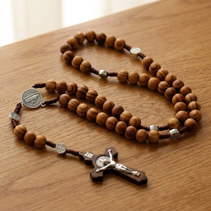 Wooden bead rosary coiled on a warm oak table